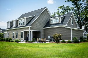 Custom home builder in Ocean County, View of custom built home backyard with green grass and patio set